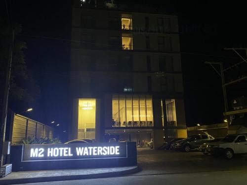 a building with a sign in front of it at night at M2 Hotel Waterside in Phayao