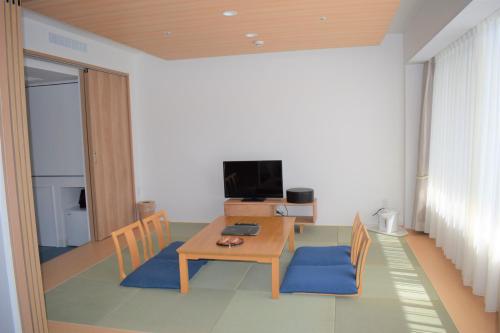 a living room with a table and a television at Kagetsuen in Hakone