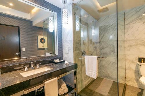 a bathroom with a shower, sink, and toilet at K Tower Boutique Hotel By Lucerna in Tijuana
