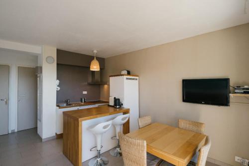 Il comprend une cuisine équipée d'une table et d'un réfrigérateur. dans l'établissement La Rade vue mer parking K6&you, à Cassis