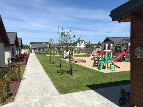 a playground with a slide and play equipment at Domki Wśród Jabłoni in Gąski