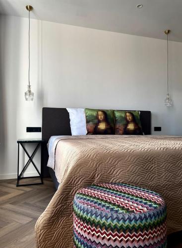 a bedroom with a bed with a ottoman next to it at Valkenhof in Valkenburg