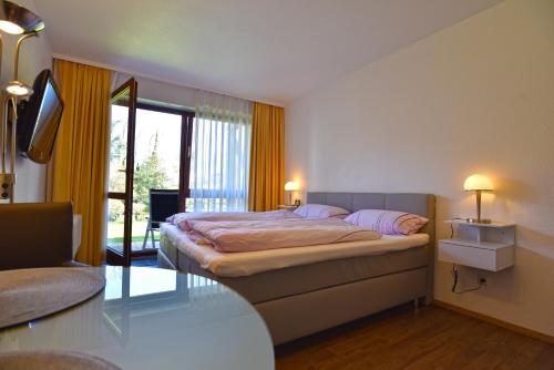een slaapkamer met een bed en een glazen tafel bij Weinbach Wohnungen in Deidesheim