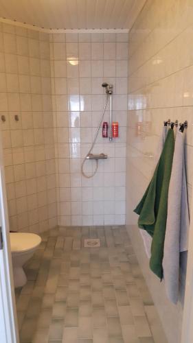 y baño con ducha, aseo y toallas verdes. en Apartment with garden and teracce, en Oulu