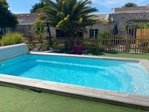 a swimming pool in the yard of a house at Le Pressoir - Gîtes et meublés de tourisme - 2 étoiles in Dolus-d'Oléron