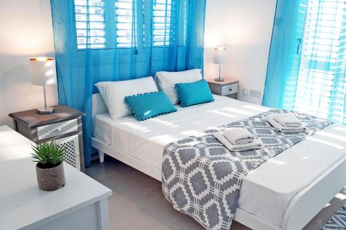 - une chambre avec un grand lit et des rideaux bleus dans l'établissement Nissini Nero, 3 bedroom villa with private pool, 5 min to the beach, à Ayia Napa