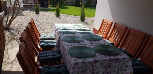 a table with a purple table cloth and green plates on it at Harmónia Parasztház és Apartman in Poroszló