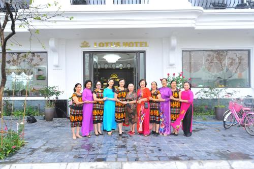 a group of women posing for a picture in front of a building at Lotus Hotel Ninh Bình in Ninh Binh