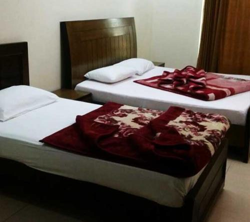 two beds sitting next to each other in a room at Butt Lodges 3 in Islamabad