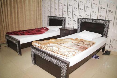 two beds sitting in a room withskirts at Butt Lodges 3 in Islamabad