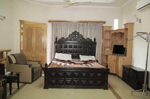 a bedroom with a large black bed in a room at Butt Lodges 3 in Islamabad