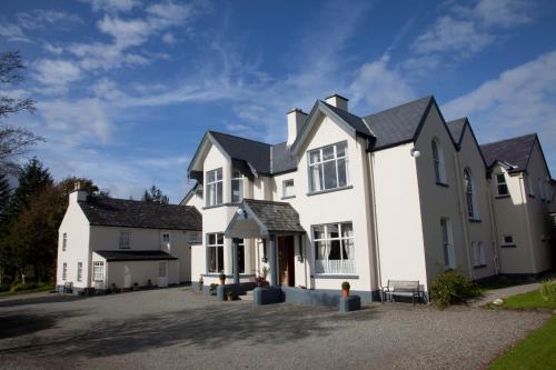 a large white house with a driveway at Woodhill House in Ardara