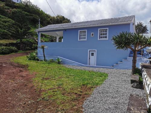 a blue house with a gravel driveway at Casa da Eira Velha in Fajã do Ouvidor