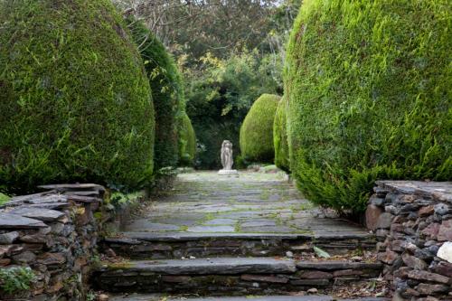 a stone path with a statue in a garden at Woodhill House in Ardara