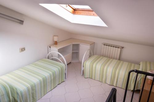 Zimmer im Dachgeschoss mit 2 Betten und einem Dachfenster in der Unterkunft Masina 45 in Porto Garibaldi