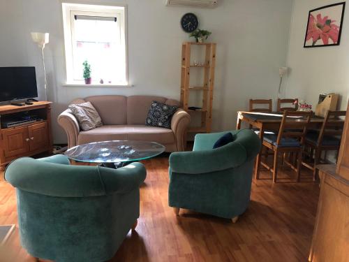 ein Wohnzimmer mit einem Sofa, 2 Stühlen und einem Tisch in der Unterkunft Eriksmala villa in Eriksmåla
