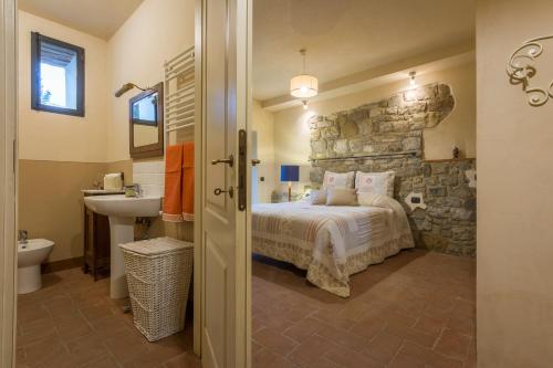 - une chambre avec un lit et un mur en pierre dans l'établissement Al Poderuzzo Private Villa with jacuzzi and garden, à Castelnuovo deʼ Sabbioni