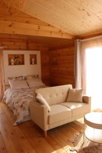a living room with a couch and a bed at CHALET ESPRIT ZEN et NATURE AVEC SPA in Saint-Hilaire-de-Riez