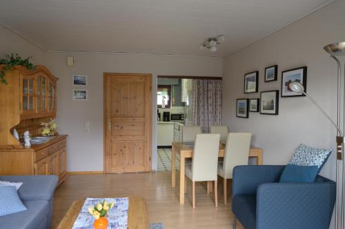 a living room with a blue couch and a table at Ferienhaus Kleine Oase in Varel
