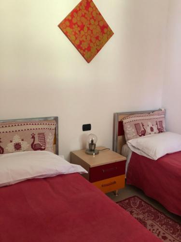 a room with two beds and a nightstand and a table at Residence Sa Pintadera in Càbras