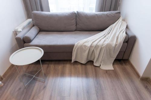 a couch with a blanket on it in a living room at Scandinavian apartment Elegant in Lviv