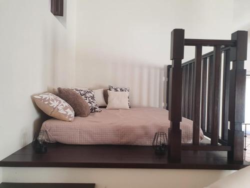 uma cama com almofadas num quarto em Open Space Rose em Iglesias