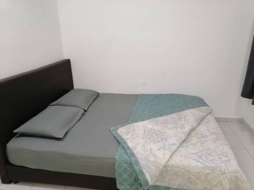 a bed in a room with a white wall at Mesahill Nilai 2 Room Condo - Fast wifi, Amazing Pool & TV in Nilai