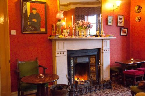 a fireplace in a room with red walls at Woodhill House in Ardara