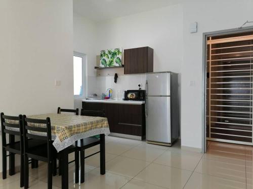 a kitchen with a table and a refrigerator at Mesahill Nilai 2 Room Condo - Fast wifi, Parking & TV in Nilai