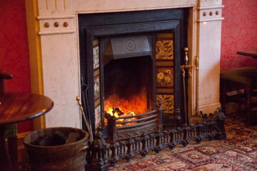 a fireplace with a fire inside of it at Woodhill House in Ardara