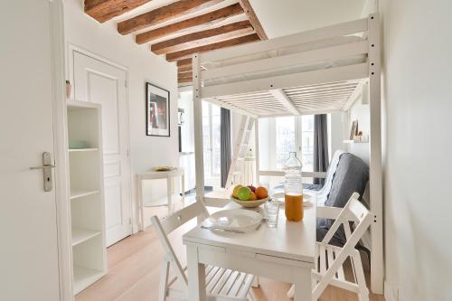 une cuisine et une salle à manger avec une table et des chaises dans l'établissement NEW Mezzanine Studio in the Heart of Paris (4F), à Paris