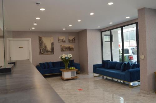 a waiting room with blue couches and a vase of flowers at Old Batumi Hotel in Batumi