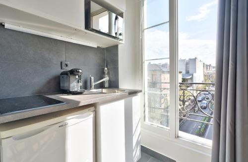une cuisine avec un évier et une fenêtre dans l'établissement NEW Mezzanine Studio in the Heart of Paris (4F), à Paris