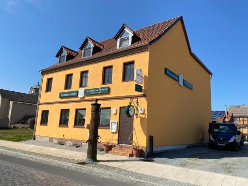 un edificio giallo sul lato di una strada di Gaststätte & Pension Pommernstube a Gartz an der Oder