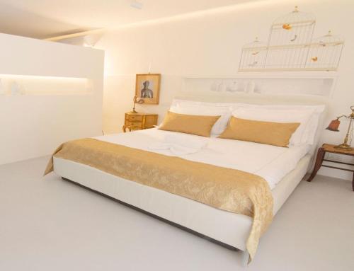 a white bedroom with a large bed with white walls at DelleFarfalle Boutique B&B in Santarcangelo di Romagna
