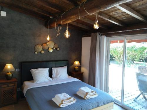 a bedroom with a bed with towels on it at Villa Liberty in Entraigues-sur-la-Sorgue