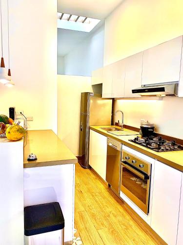 a kitchen with white cabinets and stainless steel appliances at Casa Rambla Serra Cali in Cali