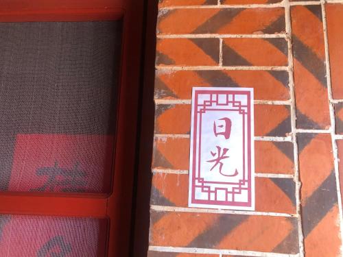 a sign on the side of a brick wall at I-Shan House in Jincheng