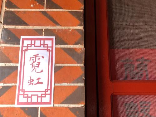 a sign on a brick wall next to a door at I-Shan House in Jincheng