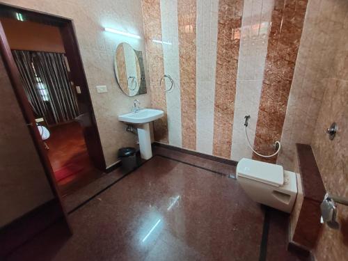 a bathroom with a sink and a toilet and a mirror at Paradise Lagoon in Kalyānpur