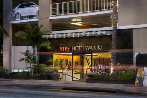 un edificio de hotel con un letrero que dice que el hotel camina en VIVE Hotel Waikiki en Honolulu