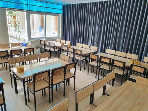 - une salle à manger avec des tables, des chaises et des fenêtres dans l'établissement Khách Sạn Tuấn Thảo Cửa Lò, à Cửa Lô