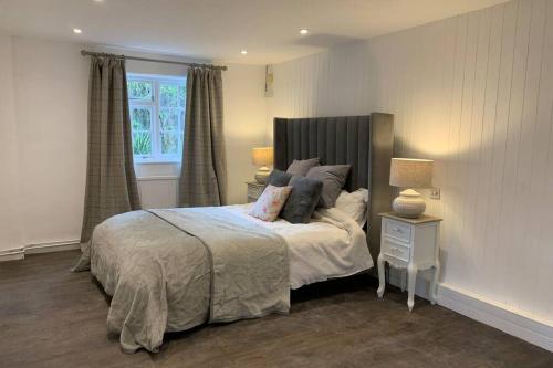 a bedroom with a bed with pillows and a window at Clock Cottage Self contained Rutland Rural Retreat in Manton
