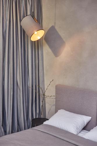 a bedroom with a bed with a lamp and a curtain at Stixiya in Odesa