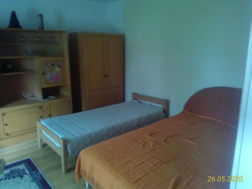a small bedroom with two beds and a dresser at Kuća za odmor Jelena in Kladovo