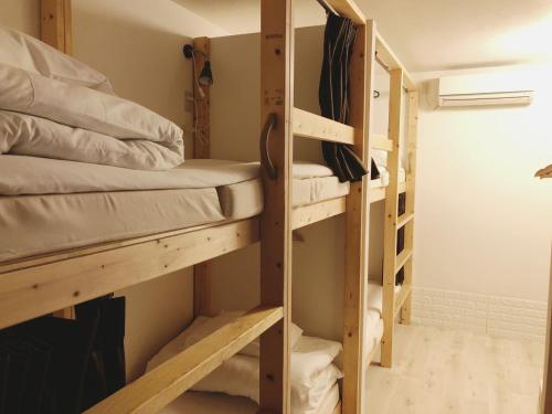 a room with bunk beds in a room at Guest House Yadomaru in Osaka