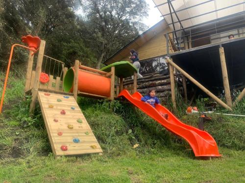 a childrens play area with a slide and slidesktop at Mirador Bosque Gran Torino Neusa in Cogua