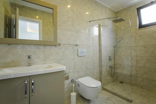 a bathroom with a shower and a toilet and a sink at VillA Esin in Kaş