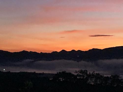 a view of a sunset with clouds and mountains at Mirador Bosque Gran Torino Neusa in Cogua