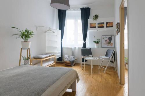 una camera con letto, tavolo e sedie di Hygge Apartman a Győr